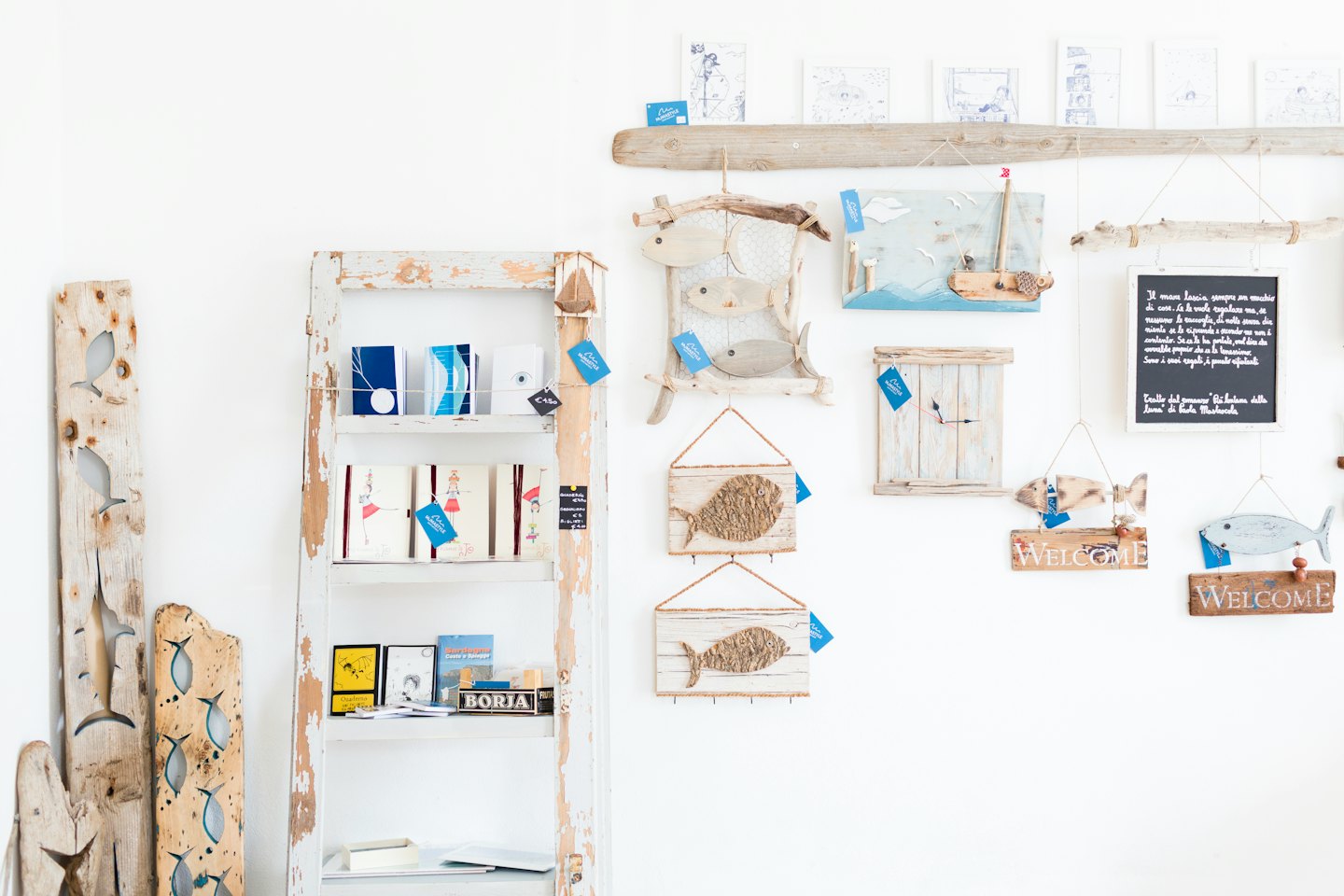 Coastal-themed shop display with wooden fish and merchandise.