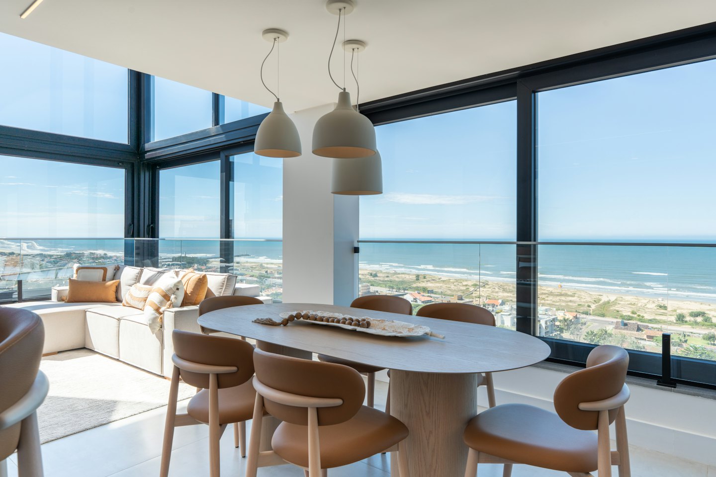 Modern dining and living area overlooking the ocean coastline.